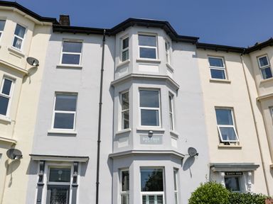 The facade of a three-story building with bay windows and a sign reading Bay Tree House in Seaton Devon