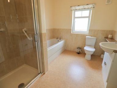 A bathroom with a shower enclosure bathtub toilet and sink at Limhus Cottage in Keswick