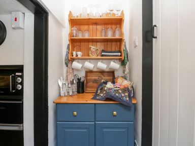 A kitchen area with a cupboard and shelf at Avonmede in Tewkesbury