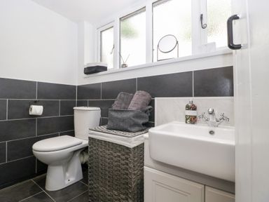 A bathroom with a toilet, sink, and towels at Avonmede in Tewkesbury