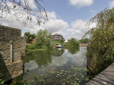 A river scene with a bridge and boat at Avonmede in Tewkesbury