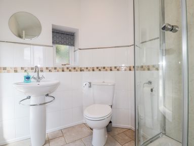 A bathroom with a sink mirror toilet and glass shower at Deanrise in Shilbottle near Alnwick