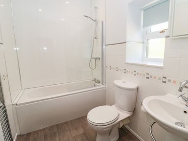 A bathroom with a bathtub shower combination toilet and sink at Deanrise in Shilbottle near Alnwick