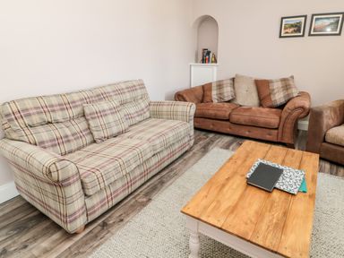 A living room with patterned and brown sofas and a wooden coffee table at Deanrise in Shilbottle near Alnwick