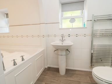 A bathroom with a bathtub sink toilet and towel rack at Deanrise in Shilbottle near Alnwick