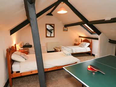 A bedroom with two single beds and a ping pong table at Harbour Cottage in Watchet