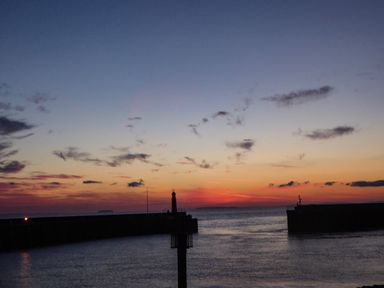 A harbor with a lighthouse at sunset at Harbour Cottage in Watchet