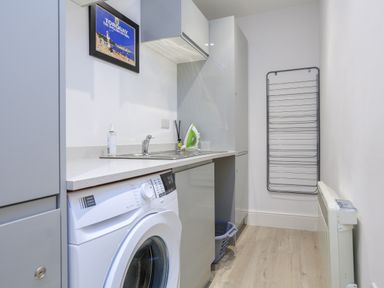 A laundry room with a washing machine sink and drying rack at Ferrystone in Kingswear near Dartmouth