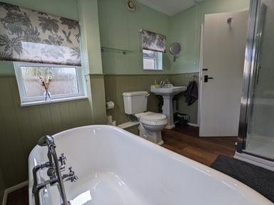 A bathroom with a bathtub toilet sink and shower at The Cottage in Tetbury