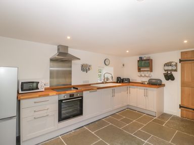 A kitchen with built in oven microwave refrigerator and dish rack at Magnolia Barn in Mark