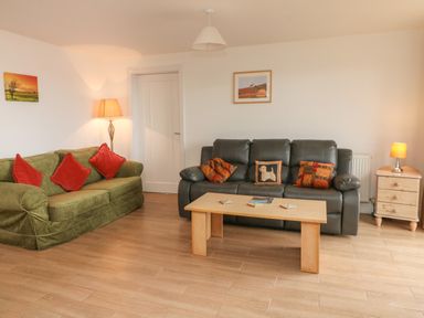 A living room with two sofas a wooden coffee table floor lamp and side table with lamp at The Outlook in Crowcombe
