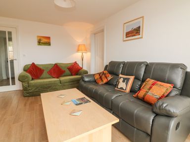 A living room with two sofas a coffee table and framed pictures on the walls at The Outlook in Crowcombe