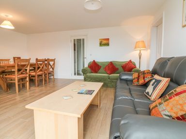 A living room with two sofas a coffee table wooden dining table and chairs at The Outlook in Crowcombe