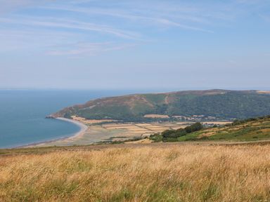 A coastal landscape with fields and hills near the sea at The Outlook in Crowcombe