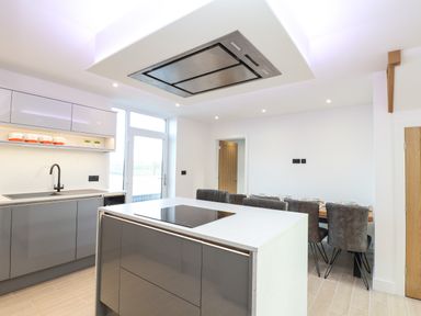 A kitchen with a cooking island and sink next to a dining table with chairs at Valley View Mullion