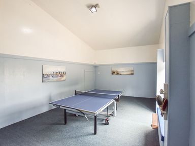 A room with a table tennis table and two paintings on the wall at Valley View in Mullion