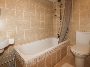 A bathroom with a bathtub shower toilet and sink at 7 Europa Court in Mawgan Porth