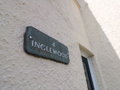 A stone plaque with the number 4 and the name Inglewood on a textured exterior wall at Inglewood Keswick