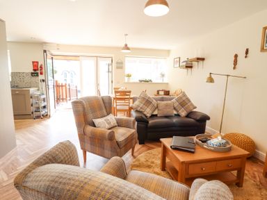 A living room with armchairs a sofa a wooden coffee table and dining table at Varley Villa in Newtown