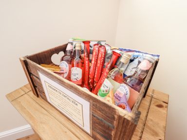 A wooden crate with bottles of drinks and snacks on a wooden table at Varley Villa in Newtown