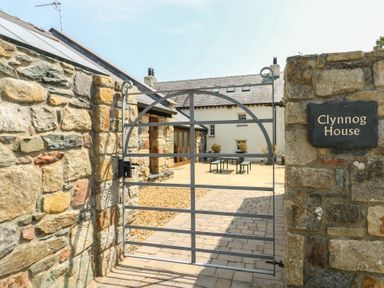 A gated entryway with a stone wall at Clynnog House in Dwyran near Newborough