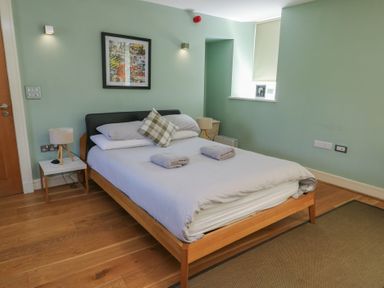A bedroom with a bed and bedside table at Clynnog House Dwyran near Newborough