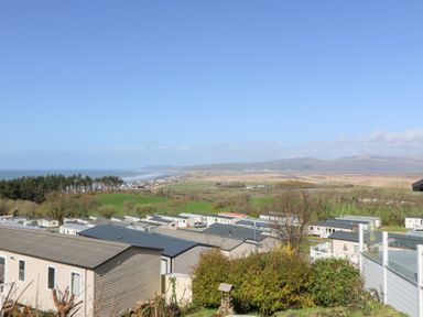 A coastal area with mobile homes and green fields near the sea at McAuliffe Lodge in Borth