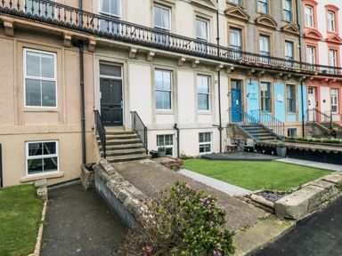 Row of terraced houses with steps leading to front doors and small front gardens in Whitby
