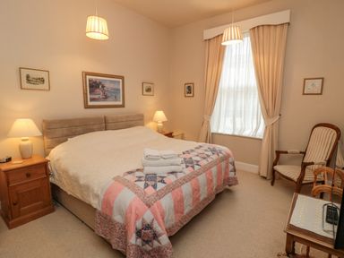 A bedroom with a double bed and bedside tables with lamps at Sandsend Sunset View in Whitby