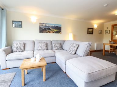 A living room with a grey sectional sofa and wooden coffee table at Pavey Ark in Ambleside