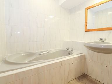 A bathroom with a bathtub a sink and a mirror at Pavey Ark in Ambleside