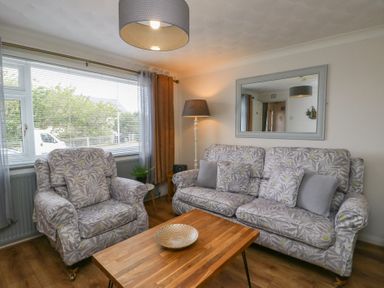 A living room with a sofa and armchair at Glasfryn in Holyhead