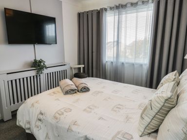 A bedroom with bed and television at Glasfryn in Holyhead