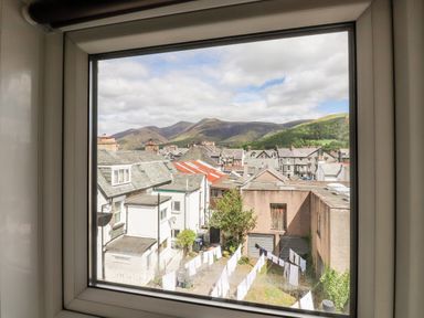 View through a window showing rooftops houses laundry on clotheslines and hills in the background at Oakhurst in Keswick