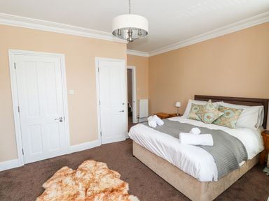 A bedroom with a double bed pillows bedside tables and a light fixture on the ceiling at Oakhurst in Keswick