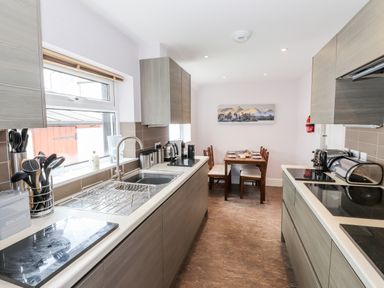A kitchen with countertops, cabinets, sink, dining table and chairs at Oakhurst in Keswick