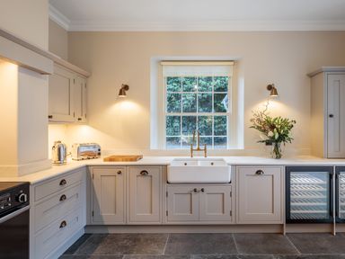 A kitchen with cabinets sink toaster kettle and flowers on countertop at The Vicarage near Rosthwaite