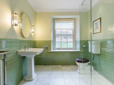 A bathroom with a pedestal sink toilet window and glass shower enclosure at The Vicarage near Rosthwaite