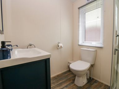 A bathroom with a toilet sink and a window with blinds at Lakeland Dream South Lakeland Leisure Lodge in Warton