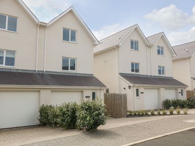 Two three-story houses with garages and shrubs in front at 3 Lon Y Dryw in Trearddur Bay