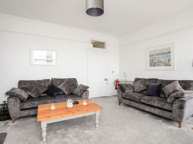 A living room with two grey sofas and a wooden coffee table at Lluest in Beaumaris