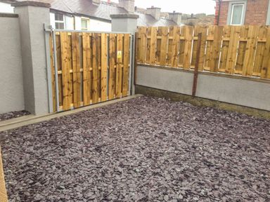 A fenced outdoor area with slate chips on the ground at The Bull Inn in Deiniolen