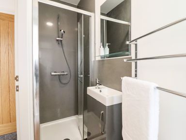 A bathroom with a shower enclosure sink with cabinet mirror and towel rack at The Bull Inn in Deiniolen