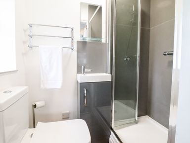 A bathroom with a toilet sink shower and towel rack at The Bull Inn in Deiniolen