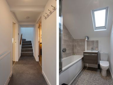 A hallway with stairs and a bathroom with bathtub toilet and skylight at Rose Cottage in St Ives