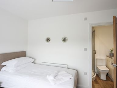 A bedroom with a bed and an en suite bathroom at Bryn Afon Farm in Llanrug