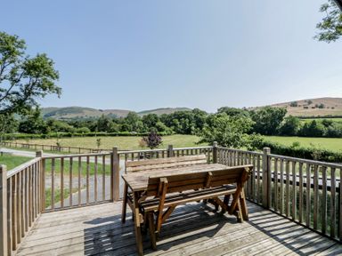 An outdoor dining area with a table and benches at Hares Rest Nantmel near Rhayader