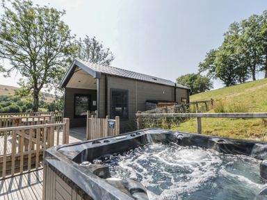 An outdoor area with a hot tub and wooden deck at Hares Rest in Nantmel near Rhayader