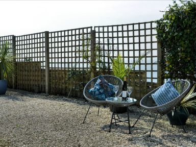 An outdoor seating area with armchairs and a table at Ocean View in Downderry
