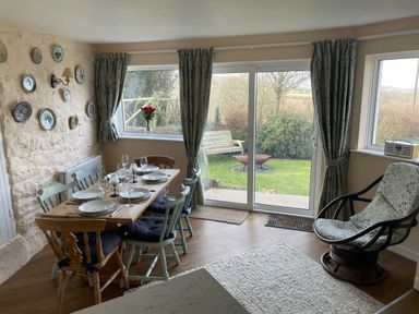 A dining room with a table set for meals at Penllain, Newport, Pembrokeshire